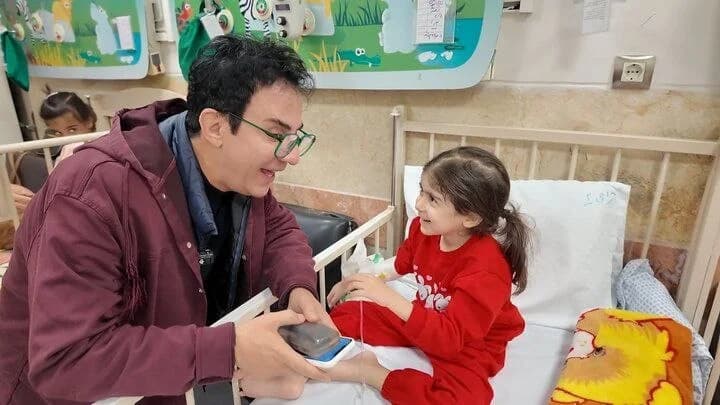 عیادت عموپورنگ از کودکان بیمار و مجروح در جنگ تحمیلی